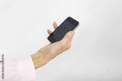 Businesswoman's hand holding smart phone in office