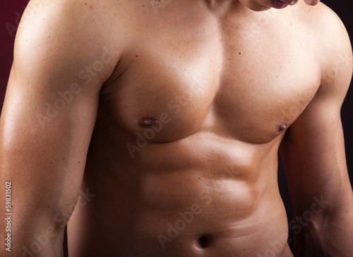 Cropped image of a beautiful man torso against black background photo