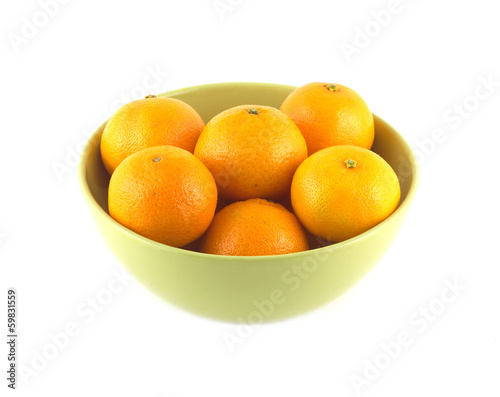 Orange tangerines inside green china bowl isolated closeup