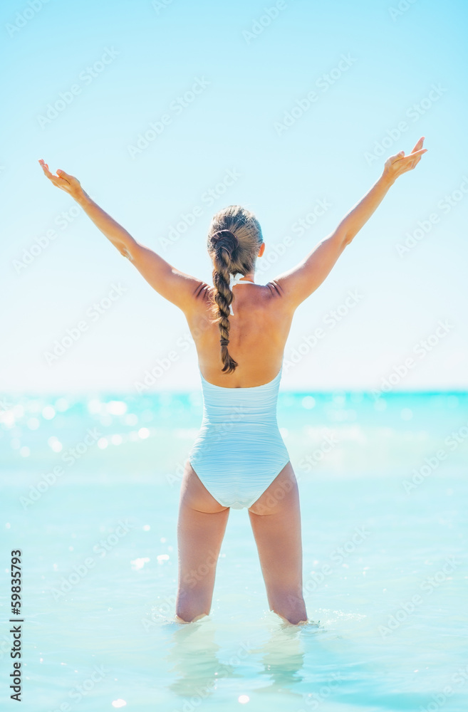 Full length portrait of woman standing in sea and rejoicing Full length portrait of woman standing in sea and rejoicing