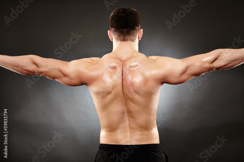 Athletic man doing bodybuilding moves for the back muscles