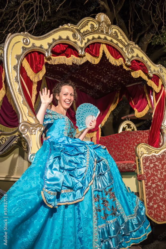 Fototapeta premium girl in blue old-fashioned dress sits in a carriage