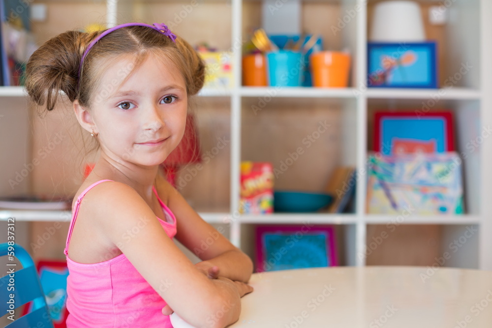 Little girl sitting at the table on playground Little girl sitting at the table on playground