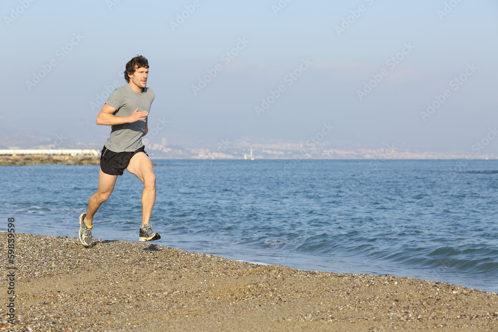 Jogger running on the beach near the water Jogger running on the beach near the water