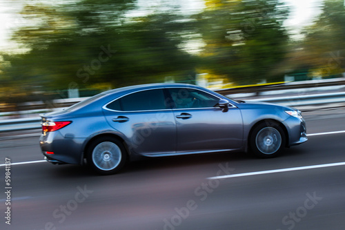 A modern sports car speeding along the road with a motion blur © Renovacio