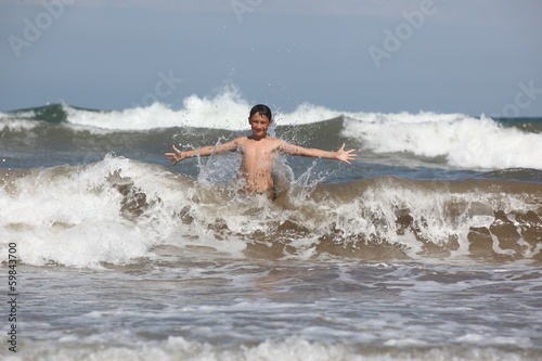 boy play with ocean waves © konstantant