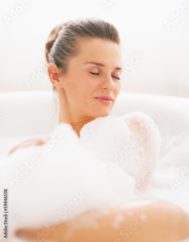 Portrait of young woman laying in bathtub