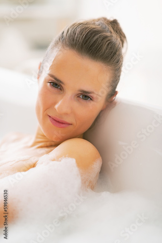 Portrait of young woman relaxing in bathtub