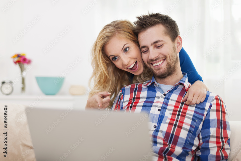 Surprised happy couple looking at laptop Surprised happy couple looking at laptop