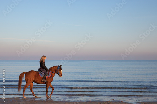 girl riding a horse on the beach