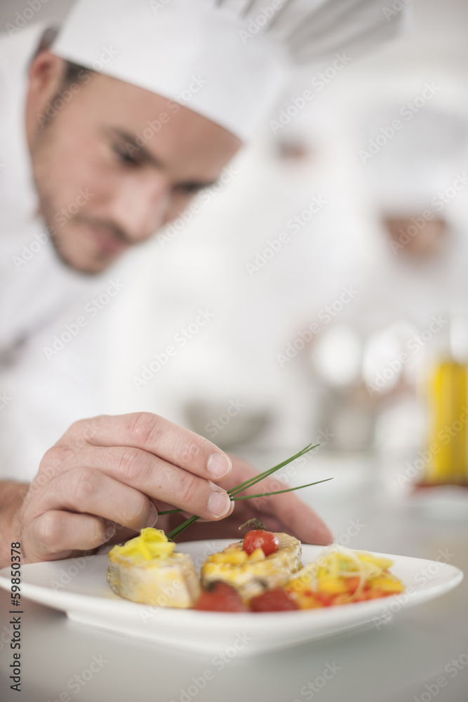 closeup on chef's hands garnishing a plate closeup on chef's hands garnishing a plate