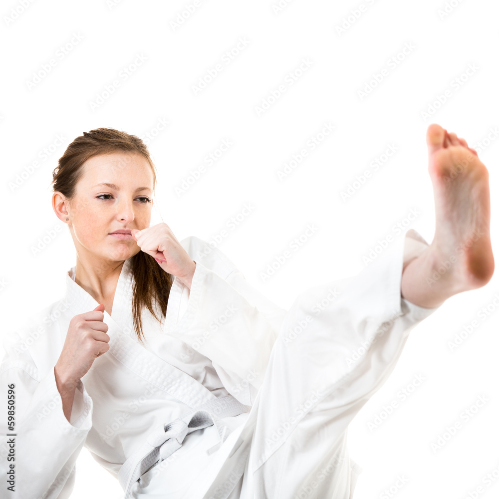 Beautiful caucasian, young, woman makes a kick in karate kimono Beautiful caucasian, young, woman makes a kick in karate kimono