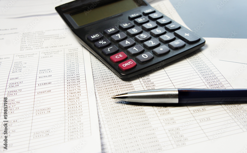 Office table with calculator, pen and accounting document Office table with calculator, pen and accounting document