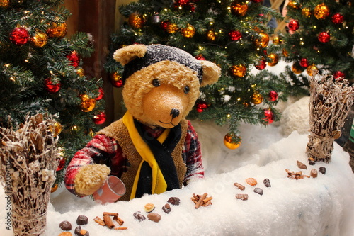 Teddybär bietet Punsch und Glühwein am Adventmarkt an photo