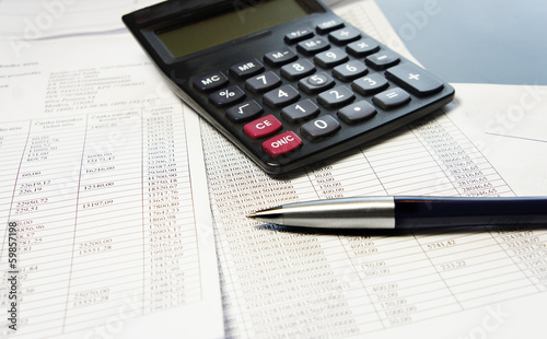 Office table with calculator, pen and accounting document