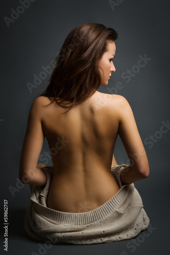 Young beautiful woman, back view, sitting on a floor