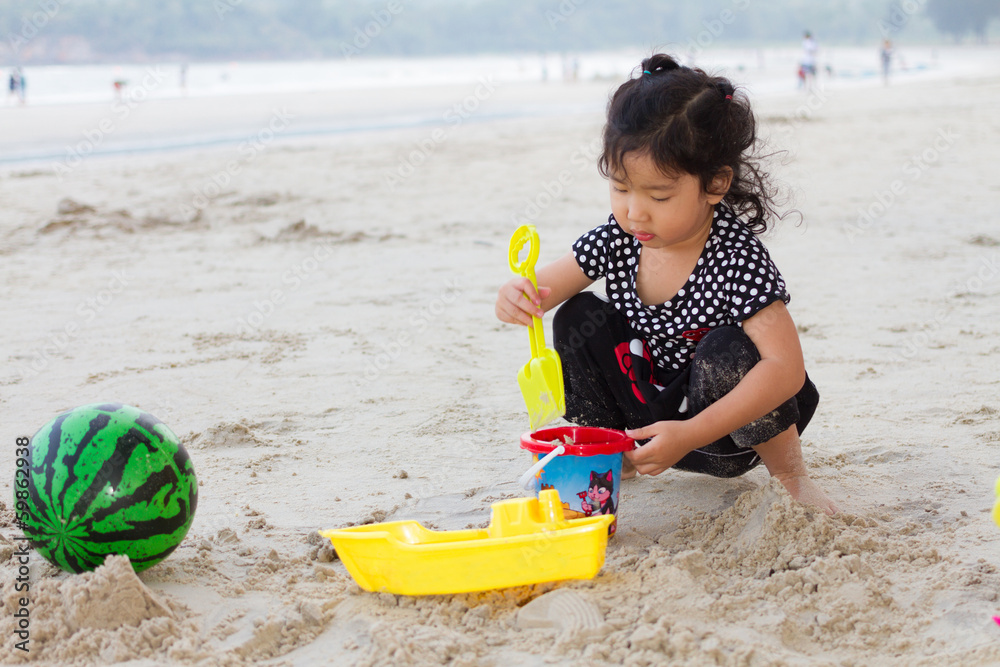 Happy child playing with sand at the beach Happy child playing with sand at the beach