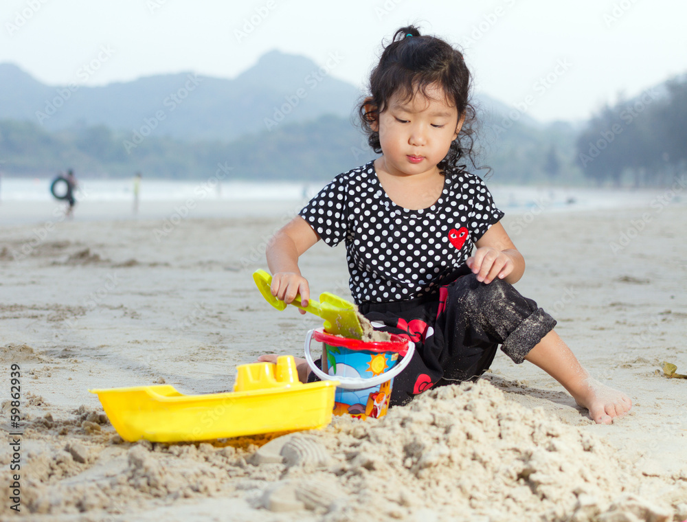 Happy child playing with sand at the beach Happy child playing with sand at the beach
