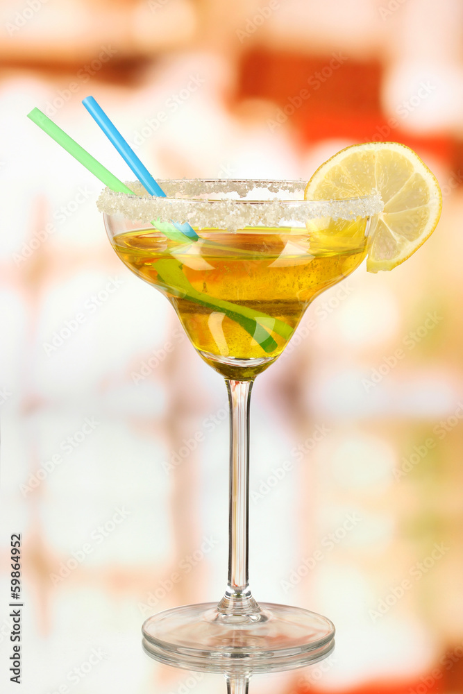 Yellow cocktail in glass on room background