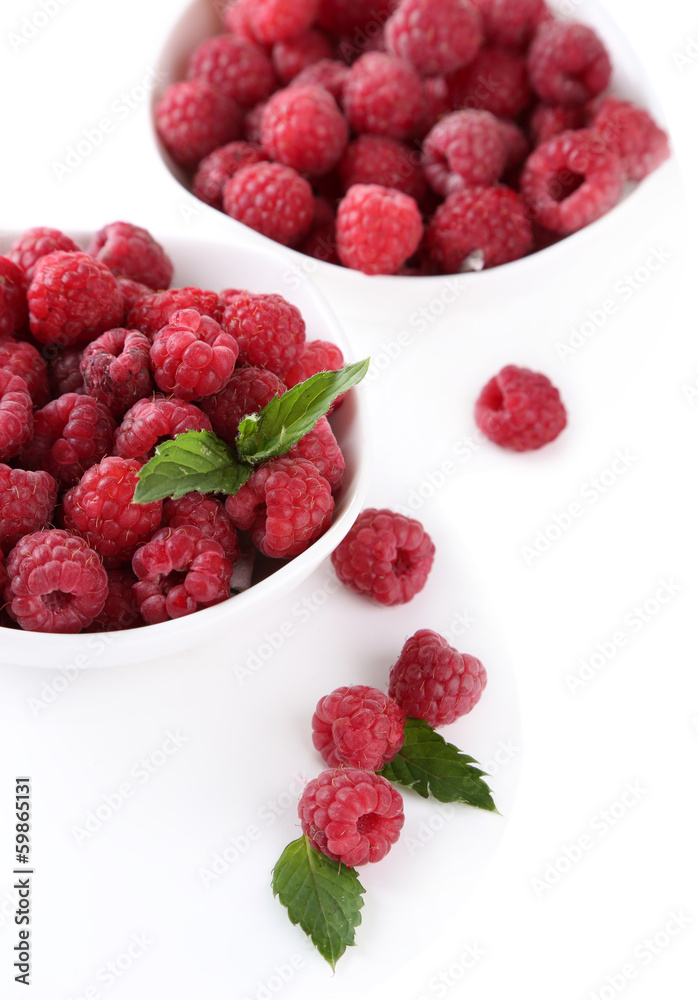 Ripe sweet raspberries in bowls, isolated on white Ripe sweet raspberries in bowls, isolated on white
