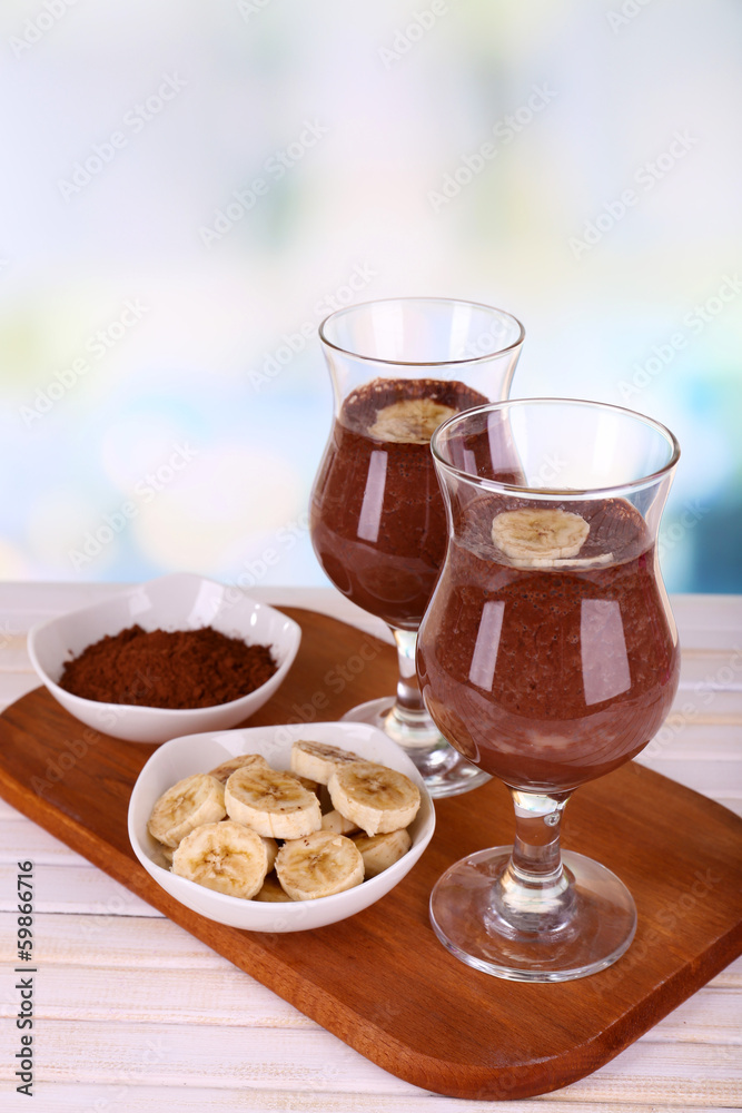 Cocktails with banana and chocolate on table on light Cocktails with banana and chocolate on table on light