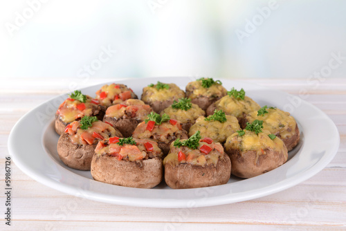 Stuffed mushrooms on plate on table on light background