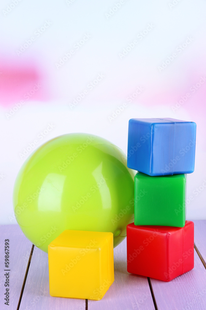 Bright ball and colorful  cubes on table on bright background