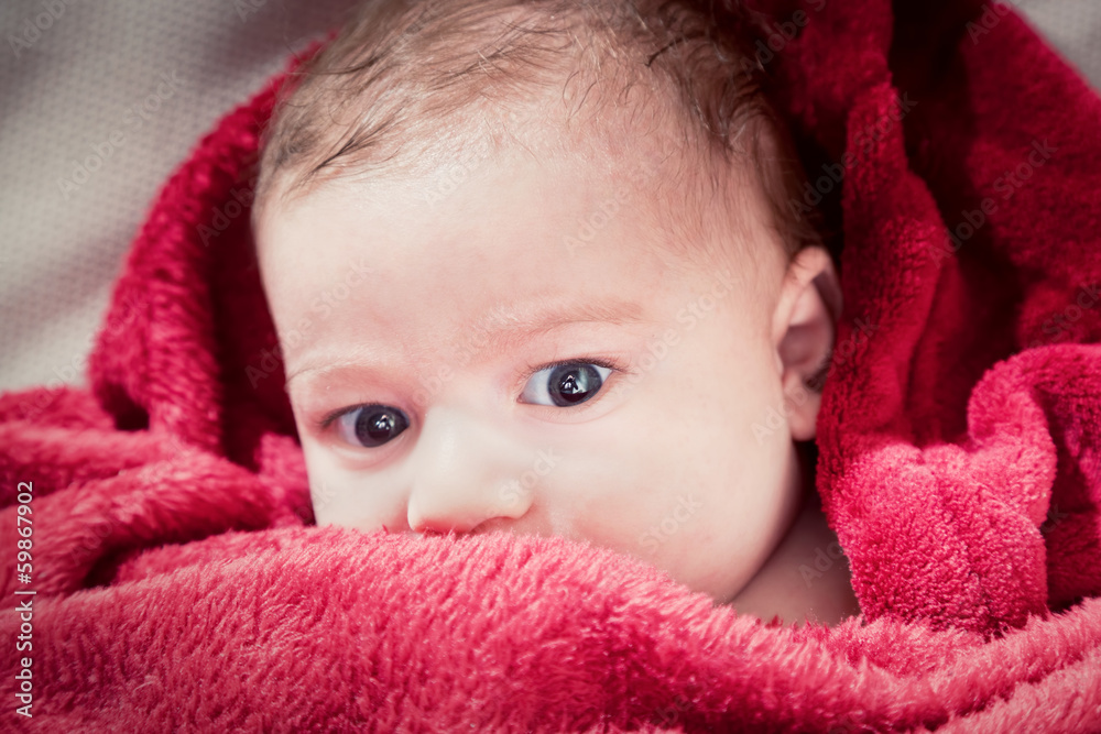 Lovely 3 months baby lying on bed covered with red blanket. Lovely 3 months baby lying on bed covered with red blanket.