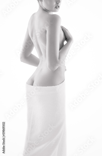 Young nude woman with towel on white