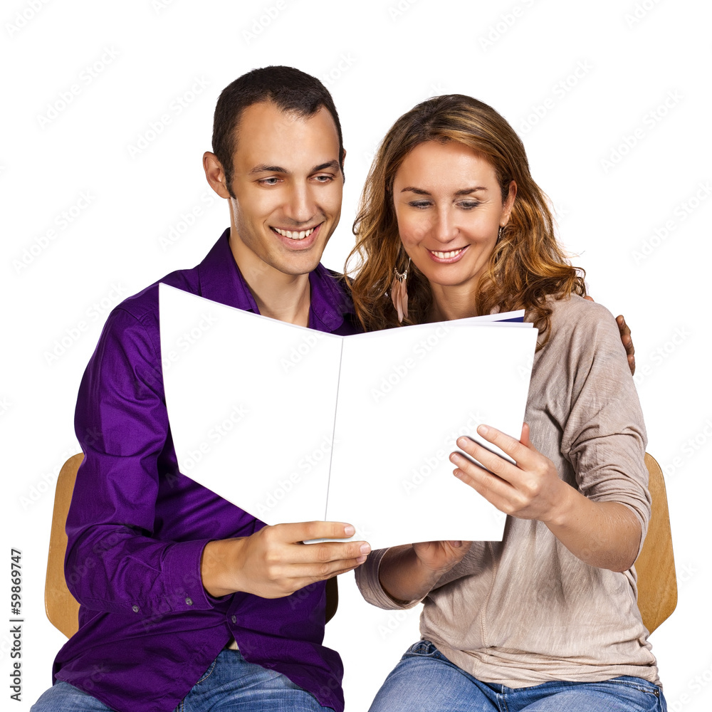 Young couple reading together a brochure with blank cover pages Young couple reading together a brochure with blank cover pages