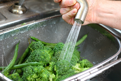 Man's Hands Washing Fresh Broccoli Vegetables