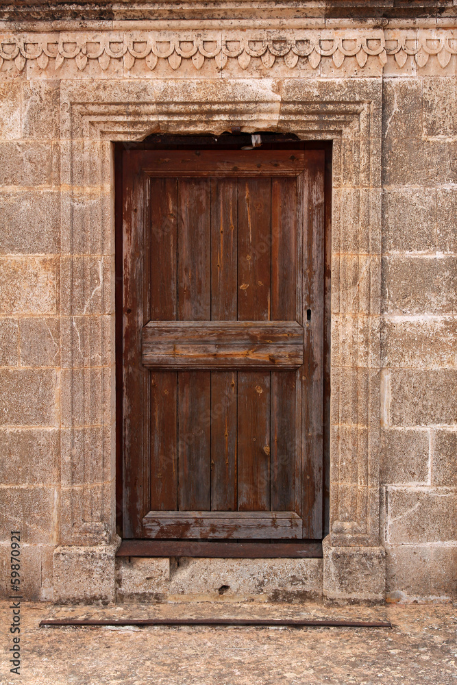 ancient wooden door in stone wall