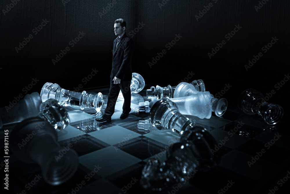 Fototapeta premium Businessman on a chessboard,.walk from the capsized dummies.