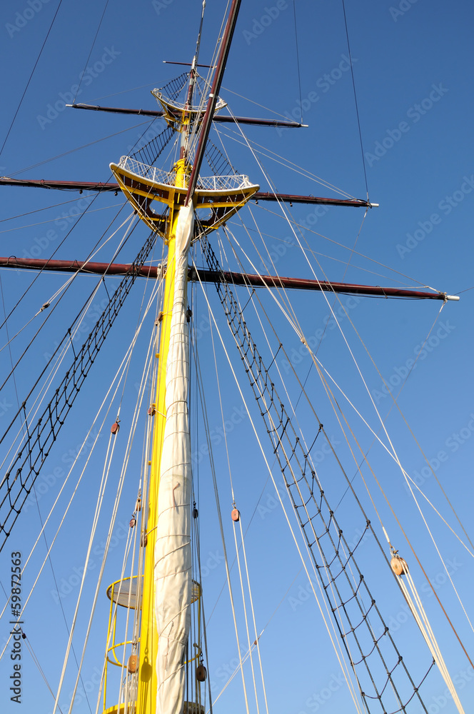 Mainmast of big sailboat with blue sky in background Mainmast of big sailboat with blue sky in background