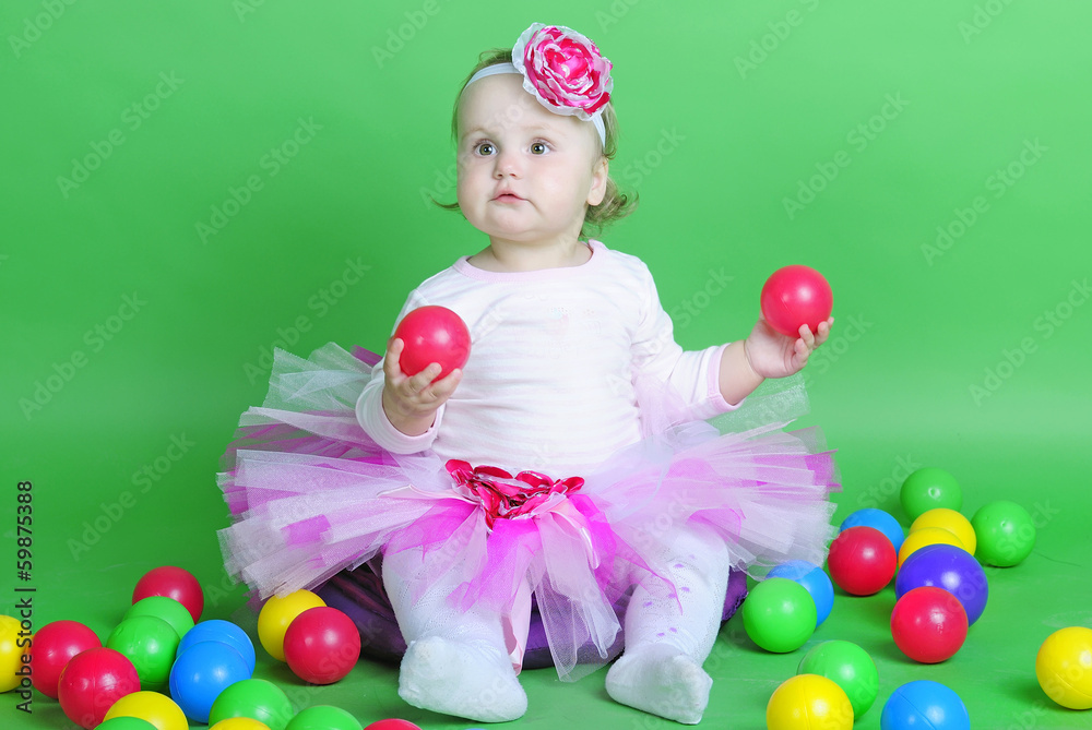 Fototapeta premium Small girl in rose suit on green background
