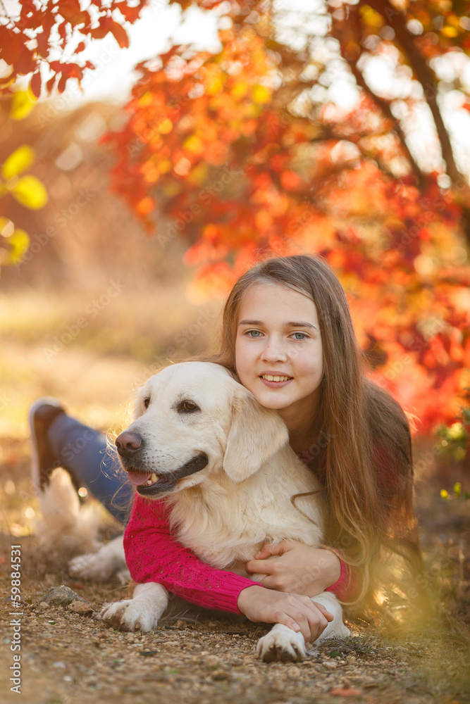 Beautiful woman and her dog posing in autumn park
