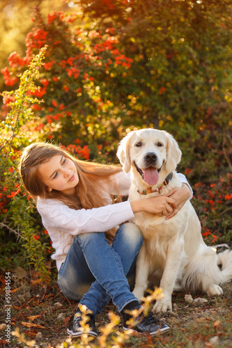 Beautiful woman and her dog posing in autumn park © GTeam