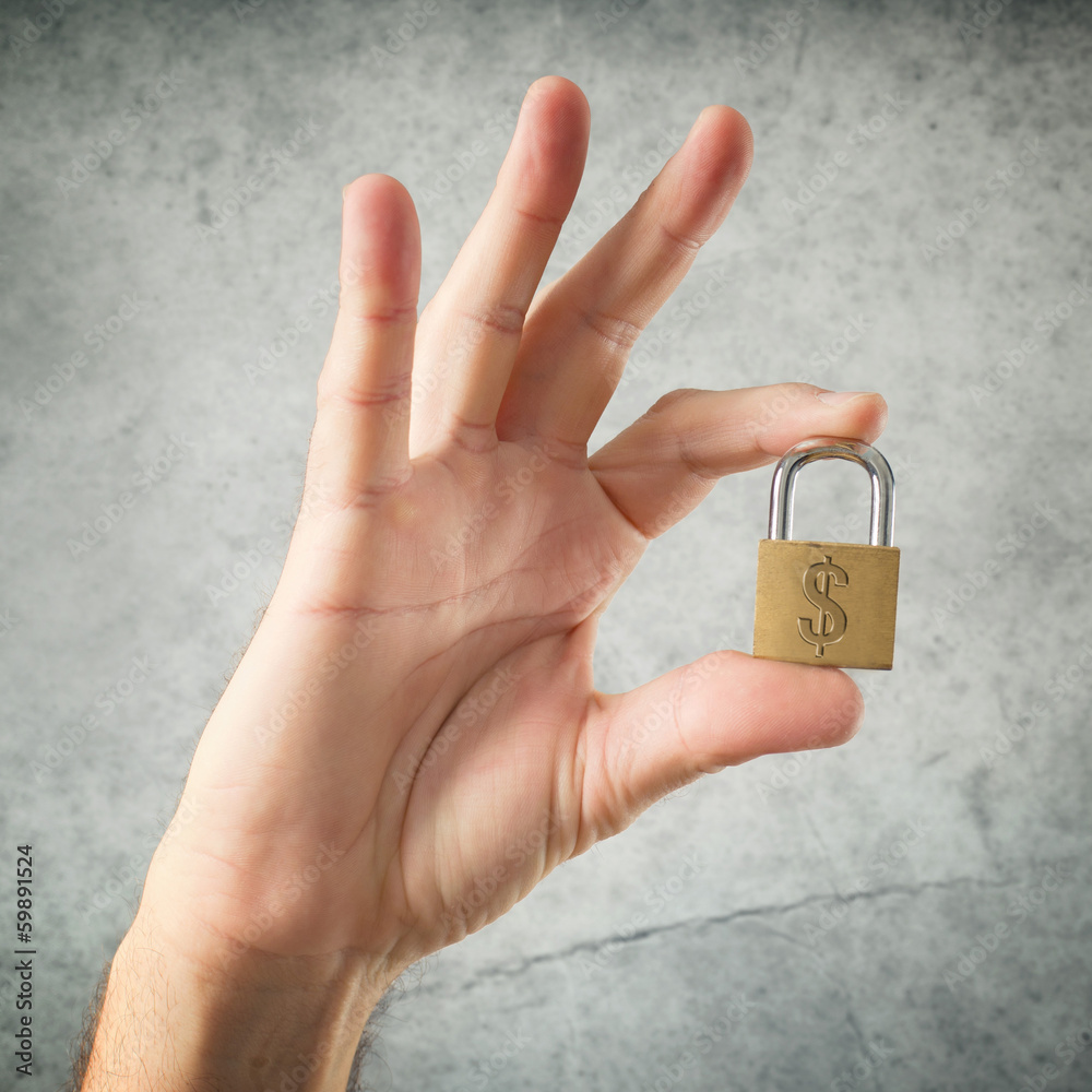 Hand holding padlock with United States dollar currency symbol Hand holding padlock with United States dollar currency symbol