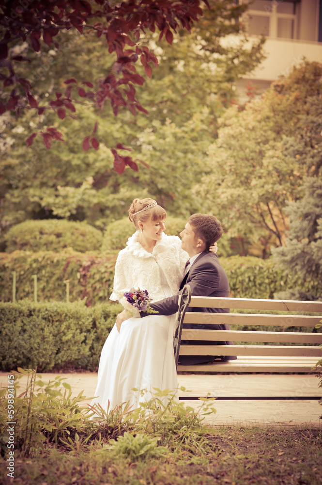 bride and groom in the park, a wedding bouquet, wedding dresses