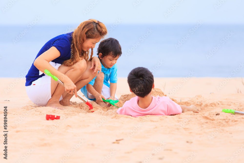 Mother and sons are playing on tropical beach