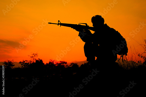 Soldier and gun in silhouette shot