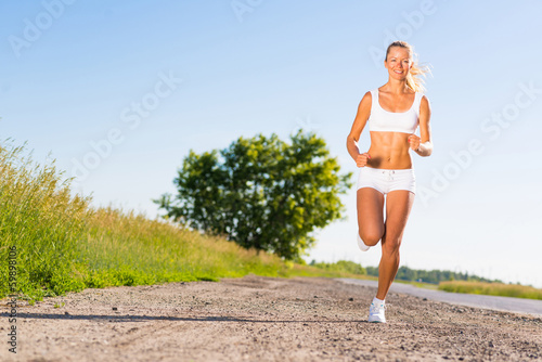 young athletic woman running on the road