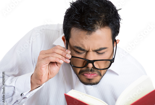 Картината върху платно Young man trying to read, having difficulties, bad vision