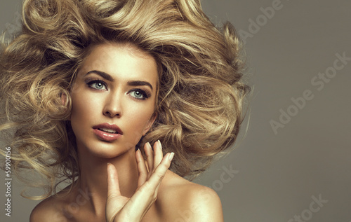 Portrait of a young blond woman with beautiful hair and green ey