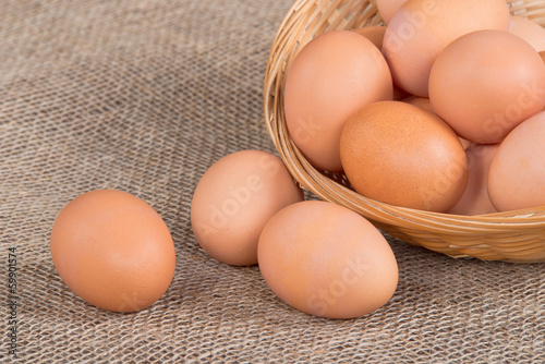 Fresh, cage-free, eggs in basket on burlap background