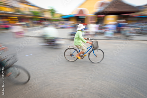 Person riding blue bike in Hoi An, Vietnam, Asia.