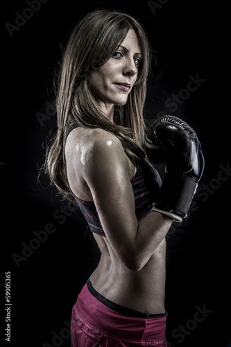 Muscular, strong woman athlete with boxing gloves © Fernando Cortés