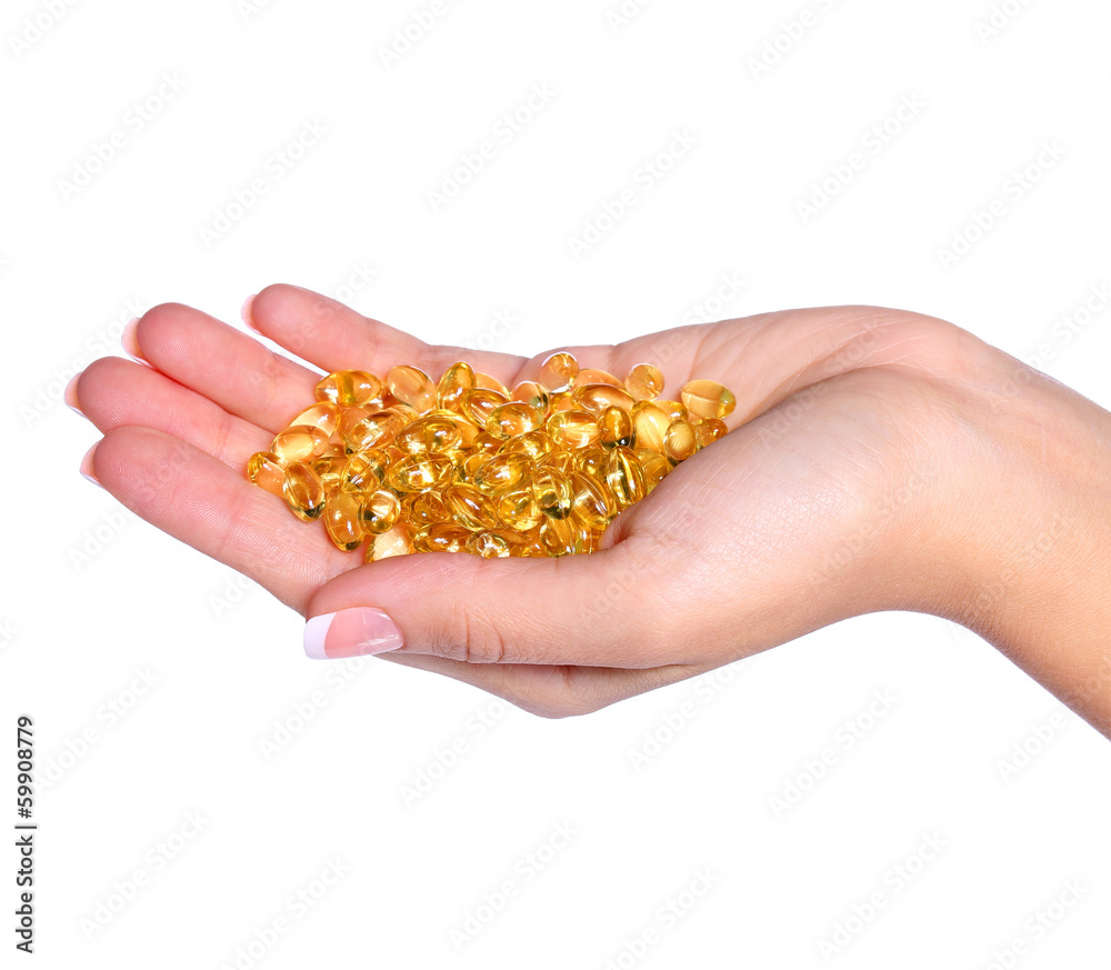 Vitamin A Capsules in Female Hand isolated on white background. Vitamin A Capsules in Female Hand isolated on white background.