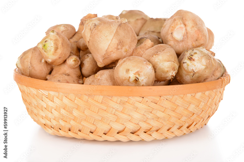 Topinambur roots in wicker basket isolated on white
