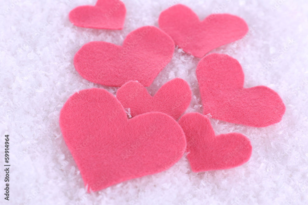 Little felt hearts on snowy background Little felt hearts on snowy background